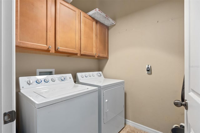 laundry area featuring washer and dryer, cabinets, and light tile patterned flooring