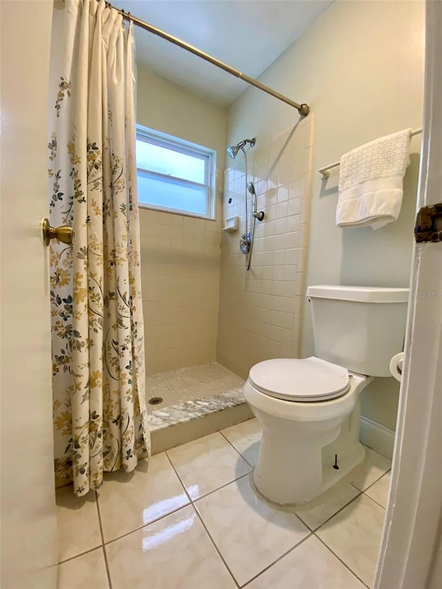 bathroom featuring toilet, tile patterned floors, and a shower with shower curtain