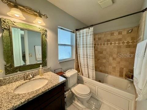 5135 Warrior Ln, Kissimmee, FL 34746 - full bathroom featuring visible vents, tile patterned floors, vanity, toilet, and shower / tub combo with curtain