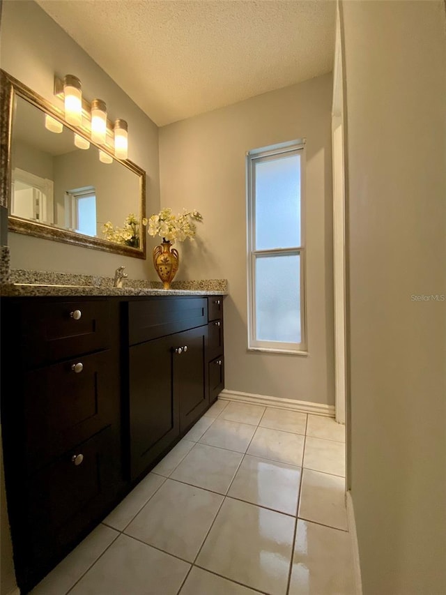 bathroom with vanity, tile patterned floors, and a textured ceiling