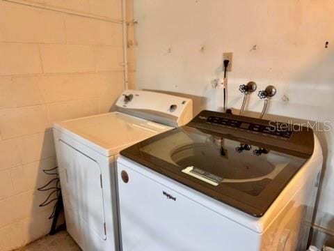 5135 Warrior Ln, Kissimmee, FL 34746 - laundry area featuring washer and clothes dryer and concrete block wall
