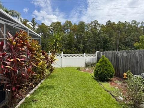 5135 Warrior Ln, Kissimmee, FL 34746 - view of yard featuring a fenced backyard and glass enclosure
