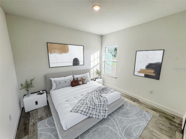 bedroom with hardwood / wood-style floors and a textured ceiling