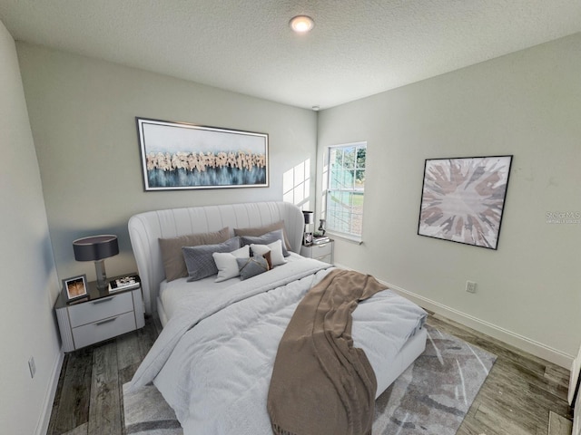 bedroom featuring hardwood / wood-style floors and a textured ceiling