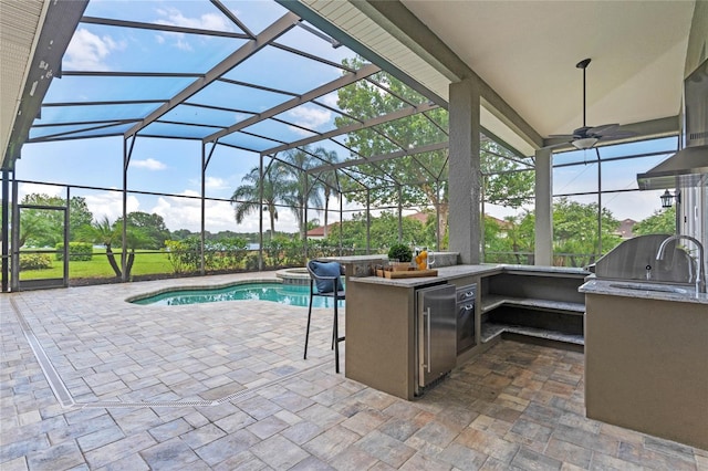 view of patio with an outdoor kitchen, an outdoor bar, and glass enclosure