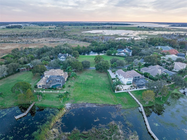 aerial view at dusk featuring a water view