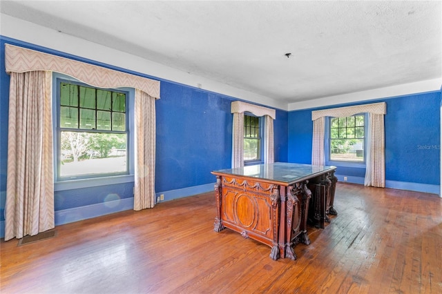 kitchen featuring wood-type flooring, a kitchen island, a textured ceiling, and a kitchen breakfast bar