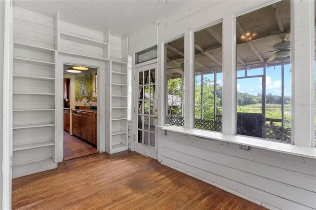 unfurnished sunroom with ceiling fan