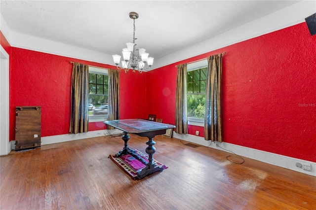 dining area featuring hardwood / wood-style flooring and a notable chandelier