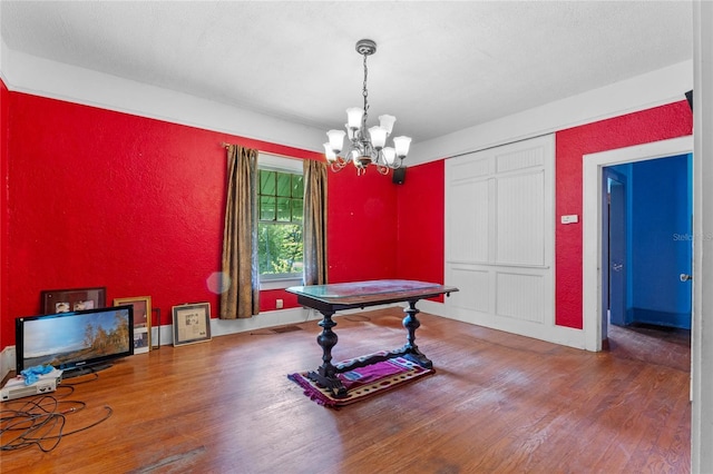 interior space with hardwood / wood-style flooring, a textured ceiling, and a chandelier