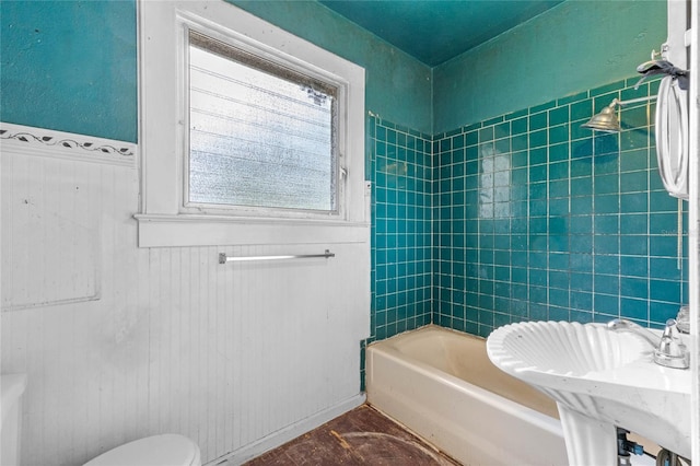 full bathroom featuring tiled shower / bath combo, sink, and toilet