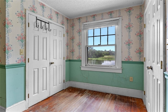 foyer featuring hardwood / wood-style floors, a textured ceiling, and a water view