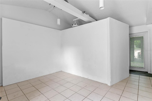 tiled empty room with vaulted ceiling