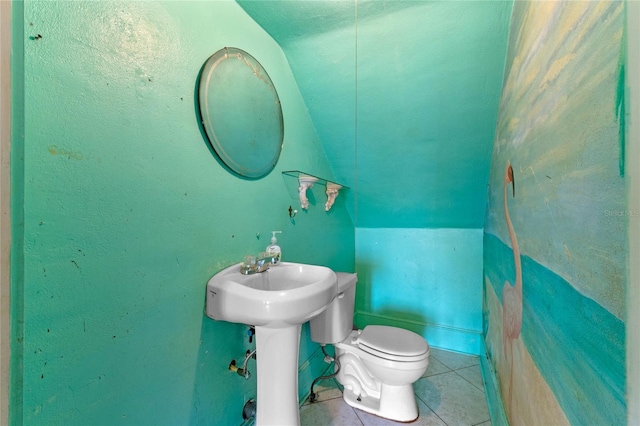 bathroom with tile patterned flooring, vaulted ceiling, and toilet