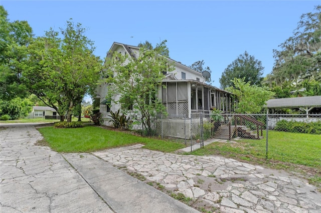 view of front facade with a front lawn and a sunroom