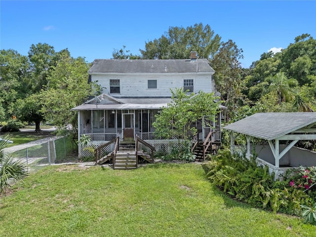 back of property featuring a lawn and a sunroom