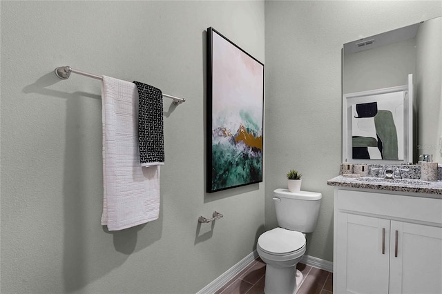 bathroom with toilet, visible vents, baseboards, and vanity