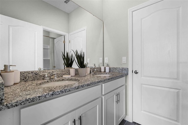 full bathroom featuring double vanity, visible vents, and a sink