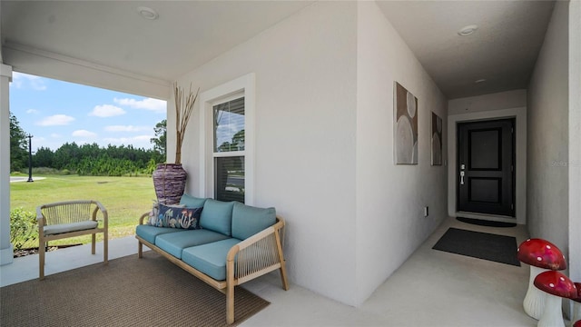 view of exterior entry with outdoor lounge area and a lawn