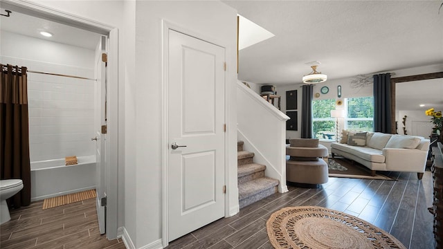 stairway with a textured ceiling and dark hardwood / wood-style flooring