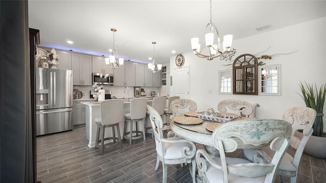 dining area featuring sink, dark hardwood / wood-style floors, and a chandelier