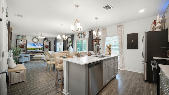 kitchen featuring gray cabinets, dark hardwood / wood-style floors, hanging light fixtures, appliances with stainless steel finishes, and sink