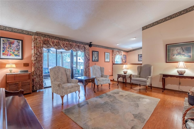 living room featuring light hardwood / wood-style flooring and a textured ceiling