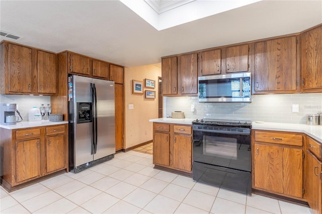 kitchen with appliances with stainless steel finishes, tasteful backsplash, and light tile patterned floors