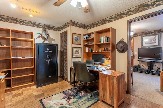 office area featuring a textured ceiling, rail lighting, ceiling fan, and light parquet flooring