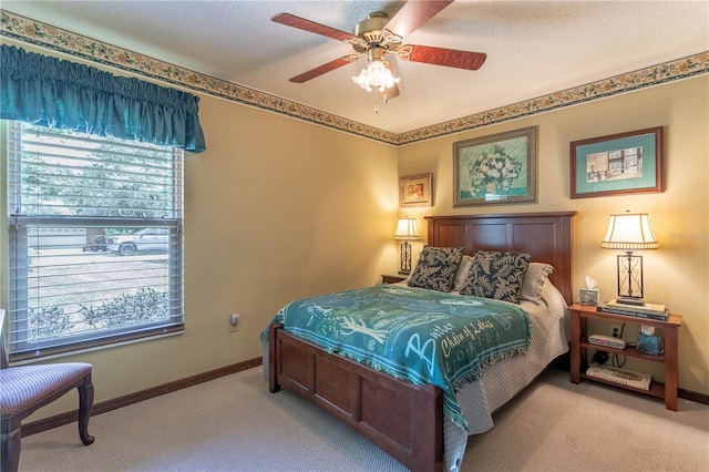 carpeted bedroom featuring ceiling fan and a textured ceiling