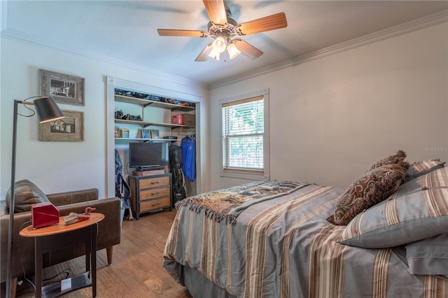 bedroom featuring ceiling fan, light hardwood / wood-style flooring, crown molding, and a closet