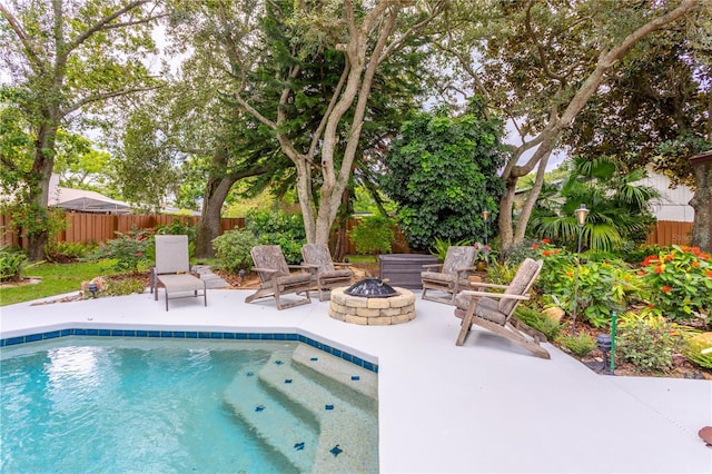 view of swimming pool with a patio area and an outdoor fire pit