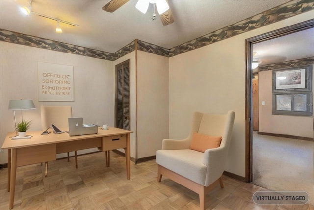 office featuring ceiling fan, baseboards, and a textured ceiling