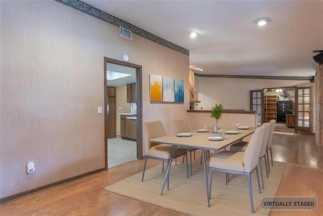 dining room with baseboards, visible vents, and wood finished floors