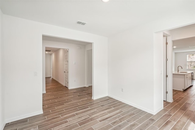 spare room with light wood-type flooring and sink