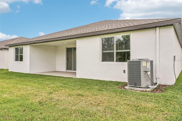 rear view of house featuring a lawn, cooling unit, and a patio