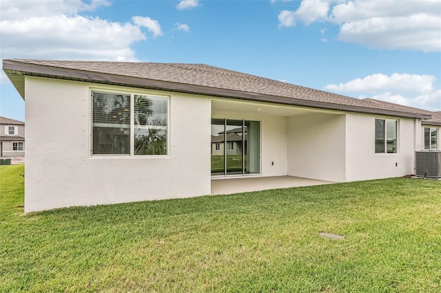 back of house featuring central AC unit, a patio area, and a lawn