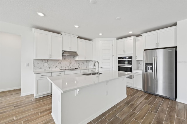 kitchen with white cabinets, stainless steel fridge, and sink