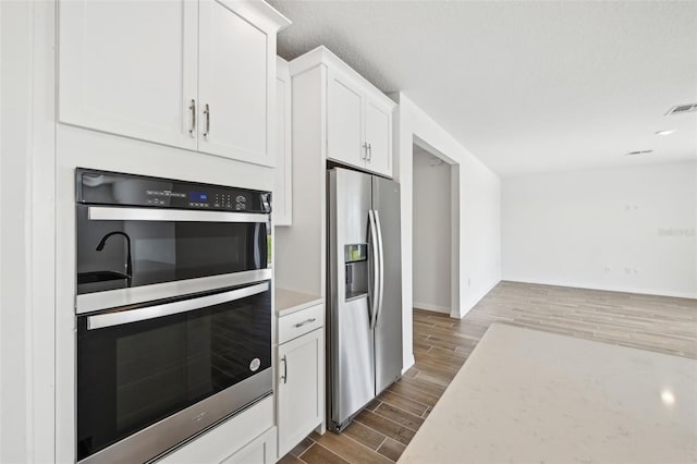 kitchen featuring light stone countertops, white cabinets, and appliances with stainless steel finishes