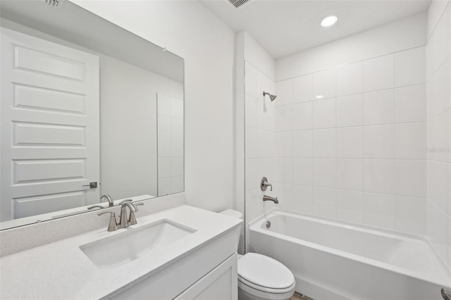 full bathroom featuring vanity, tiled shower / bath combo, and toilet