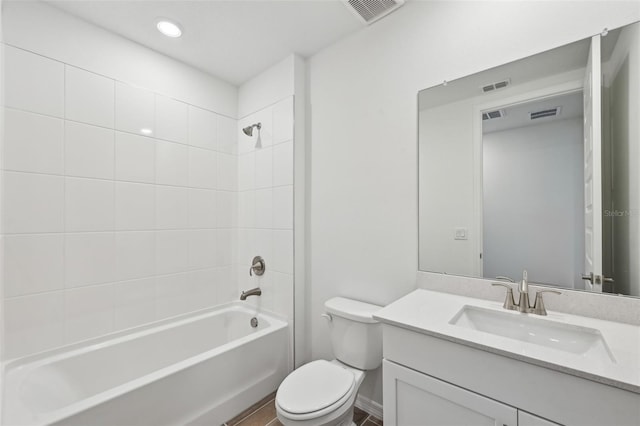 full bathroom featuring vanity, tiled shower / bath combo, and toilet