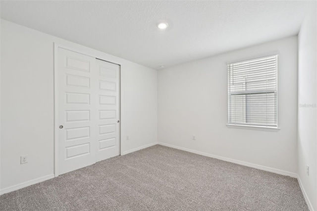 unfurnished bedroom featuring carpet flooring and a closet