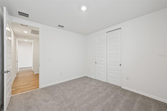 unfurnished bedroom with a closet and carpet flooring