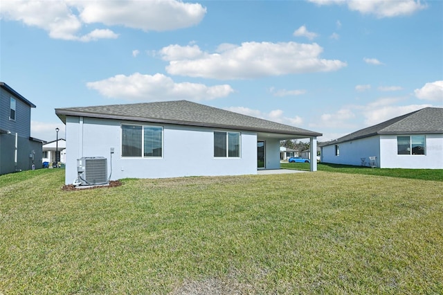 back of house with central air condition unit and a yard