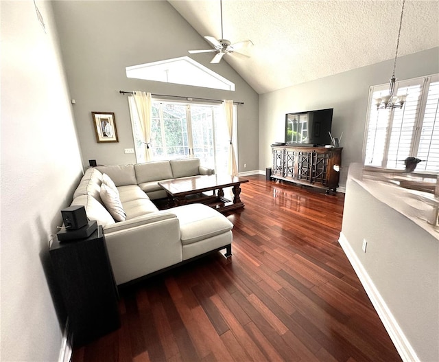 living room with ceiling fan with notable chandelier, dark hardwood / wood-style floors, a textured ceiling, and lofted ceiling