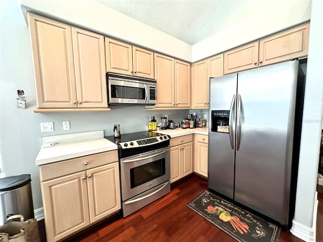 kitchen featuring light brown cabinets, vaulted ceiling, appliances with stainless steel finishes, a textured ceiling, and dark hardwood / wood-style floors