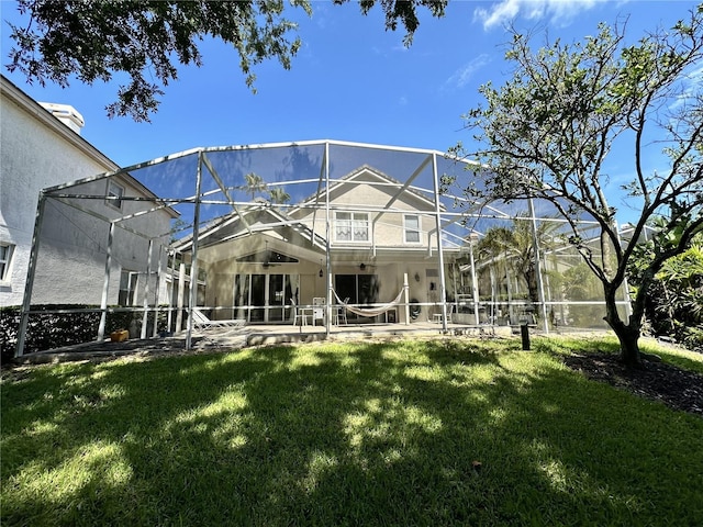 back of house featuring a lanai, a lawn, and a patio