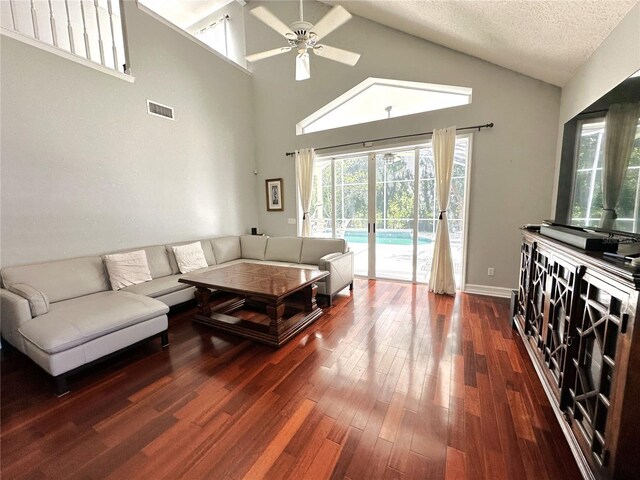 living room featuring a towering ceiling, a textured ceiling, french doors, ceiling fan, and dark hardwood / wood-style floors