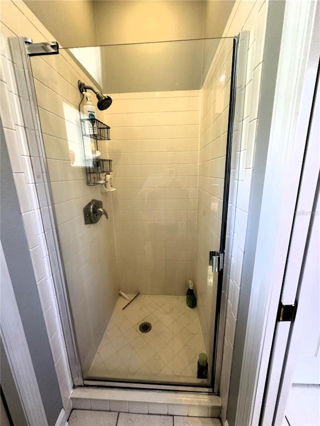 bathroom featuring tile patterned flooring and a shower with shower door