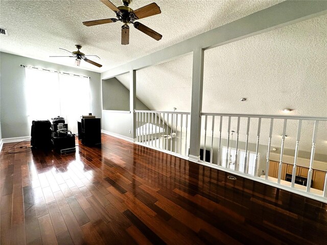 interior space with vaulted ceiling, a textured ceiling, and wood-type flooring